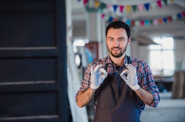 İşçi el Çift Ok işareti Atölyesi'nde gülümseyen