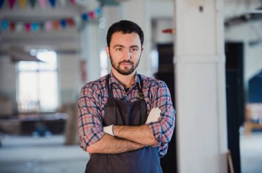 Atölye benim dünyam. Mutlu genç erkek marangoz silah tutmak geçti