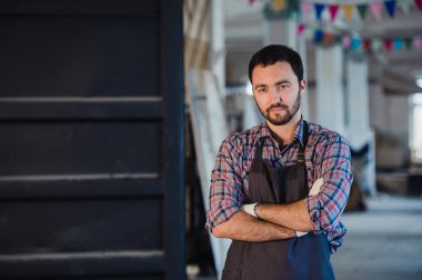 Atölye benim dünyam. Mutlu genç erkek marangoz silah tutmak geçti