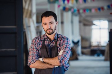 Atölye benim dünyam. Mutlu genç erkek marangoz silah tutmak geçti