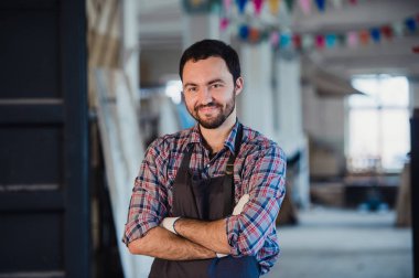 Atölye benim dünyam. Mutlu genç erkek marangoz silah tutmak geçti
