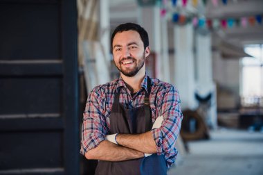 Atölye benim dünyam. Mutlu genç erkek marangoz silah tutmak geçti