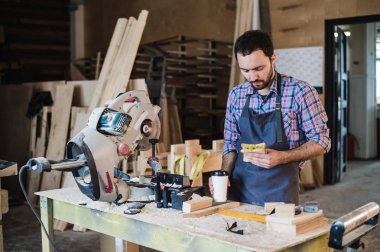 Neşeli marangozluk işçi sandviç yeme bir atölyede Öğle Yemeği