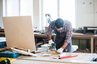 Onun atölyesinde elektrik değirmeni ile marangoz