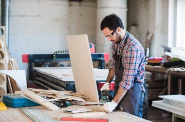 Onun atölyesinde elektrik değirmeni ile marangoz