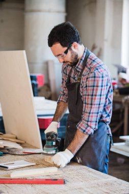 Onun atölyesinde elektrik değirmeni ile marangoz