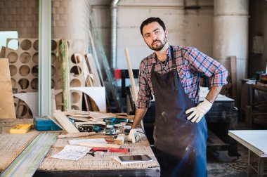 Marangoz planlara dikkatlice bakıyor.