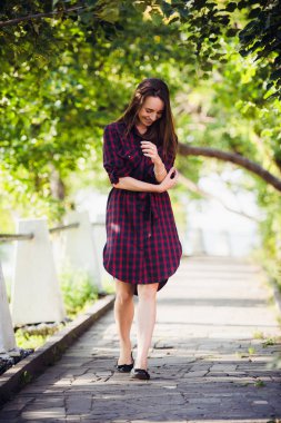 Çekici genç kadın bacağı parkta yürürken gösterir