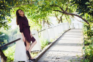 Çekici genç kadın bacağı parkta yürürken gösterir