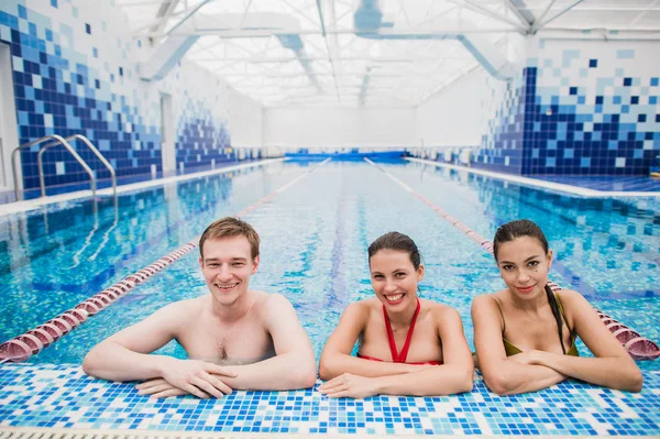 Amigos felizes na aula de piscina aprendendo a nadar e se divertir — Fotografia de Stock