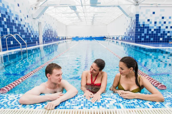 Adultos jóvenes divirtiéndose hablando en la piscina al aire libre — Foto de Stock