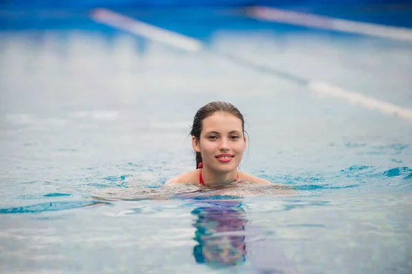 Retrato sonriente de una hermosa mujer en la piscina — Foto de Stock