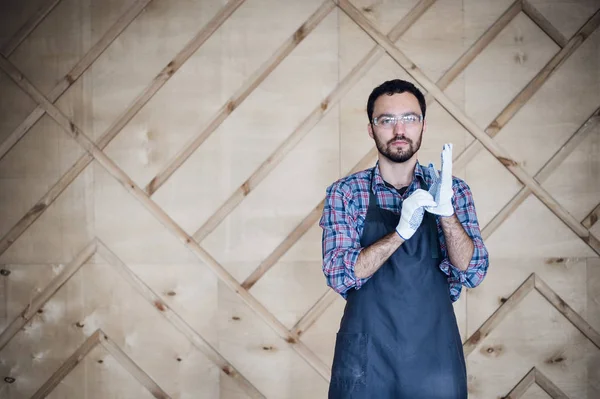 Eldiven giymiş atölyede çalışan bir marangoz portresi