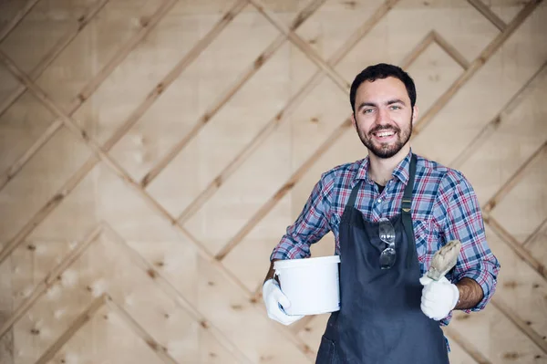 Eldiven ve gözlük ellerle kalça üzerinde giyen genç erkek marangoz