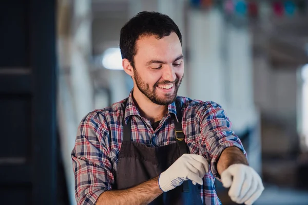 Счастливый молодой плотник в мастерской, улыбающийся — стоковое фото