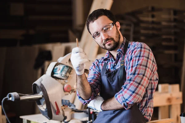 Master vende sus propios productos. El carpintero masculino tiene una idea en el taller sosteniendo la pluma en su mano — Foto de Stock