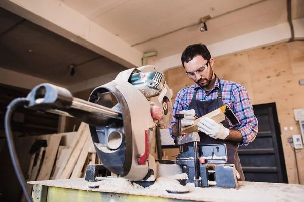 Framing contractor using a circular cut off saw to trim wood studs length. — Stock Photo, Image