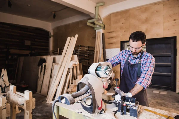 Carpintero usando sierra circular para madera en su taller — Foto de Stock