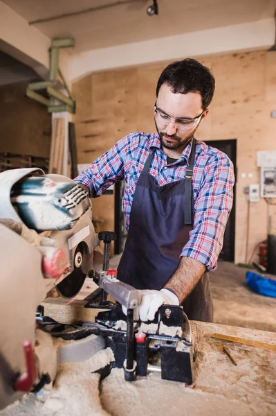 Carpintero usando sierra circular para madera en su taller — Foto de Stock