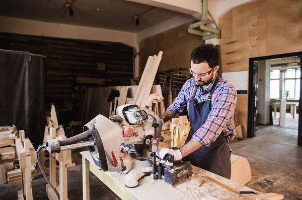 Jovem artesão de uniforme que trabalha na carpintaria — Fotografia de Stock