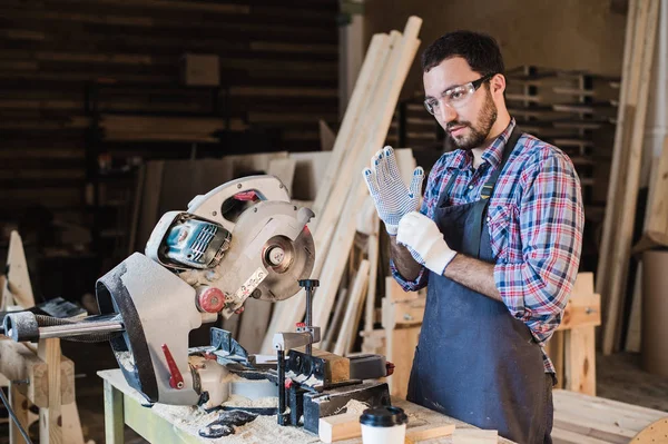 Joven artesano en uniforme trabajando en carpintería — Foto de Stock