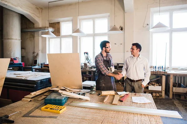 Charpentier et son collègue serrant la main à l'atelier de menuiserie — Photo