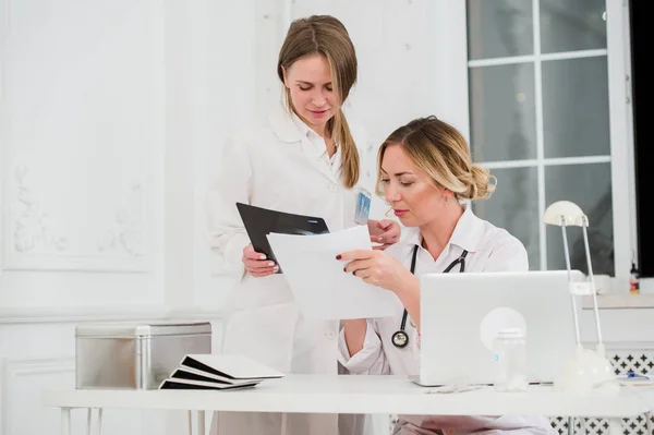 Médico y enfermera mirando los documentos en el consultorio médico — Foto de Stock