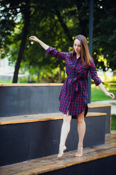 Flicka piruett går på en tiptoes mot sommaren park. — Stockfoto