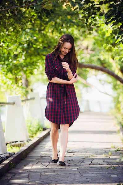 Jolie jeune femme montre sa jambe tout en marchant dans le parc — Photo