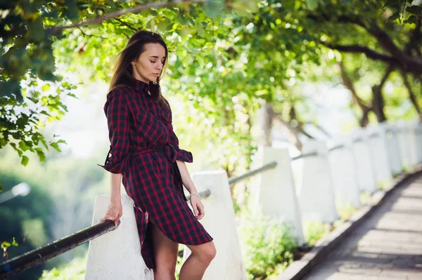 Jolie jeune femme montre sa jambe tout en marchant dans le parc — Photo