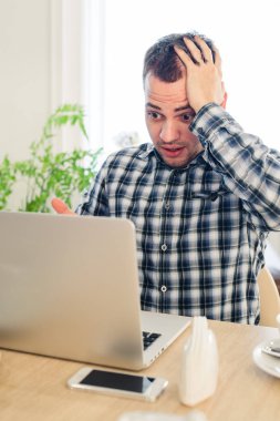 Hasta ve yorgun hissediyorum. Hayal kırıklığına uğramış genç adam kafa café'de çalışan dizüstü bilgisayara bakarken elinde tutan