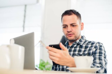 Portre portre, mor genç adam vurguladı şaşırttı, dehşete ve rahatsız, cep telefonundan gördüğü tarafından kazak, şok izole kapalı arka plan.