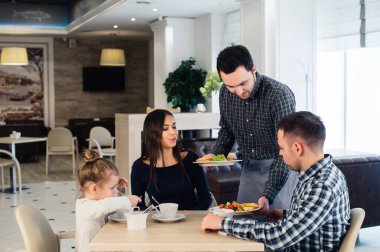 Aile içinde bir restoran hizmet veren ve tam plaka getiren garson