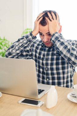 Portre portre, vurguladı şaşırttı, dehşete ve rahatsız, genç adam, şok cep telefonundan gördüğü tarafından izole kapalı arka plan.