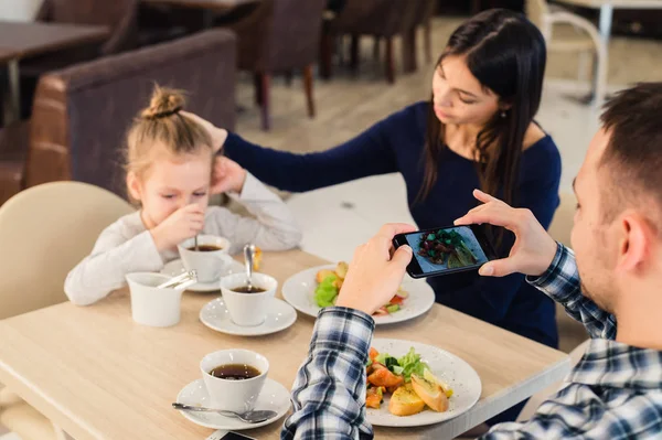 休闲、 技术、 生活方式和人们的观念 — — 幸福的家庭，与智能手机拍照的餐厅的菜 — 图库照片