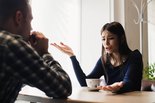 Young couple arguing in a cafe. Relationship problems.