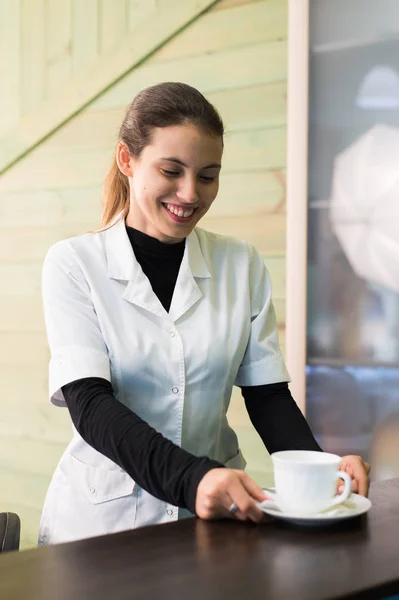 Kobiece pielęgniarka turystycznej, Dokonywanie kawy praca w nowoczesnym biurze — Zdjęcie stockowe