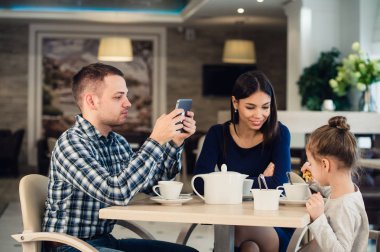 Modern aile değerleri. Elektronik cihazlar tablet pc, karısı ve kızı mutsuz bir kafede oturan kullanma hakkında bağımlısı baba