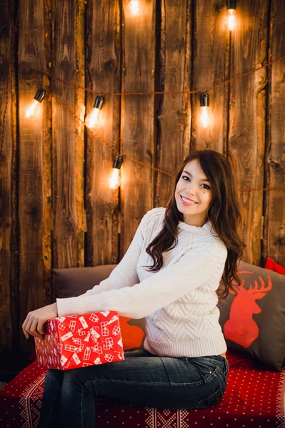 Smiling young woman with a gifts and Christmas tree — Stock Photo, Image