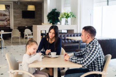 Birlikte bir restoranda masada oturan aile