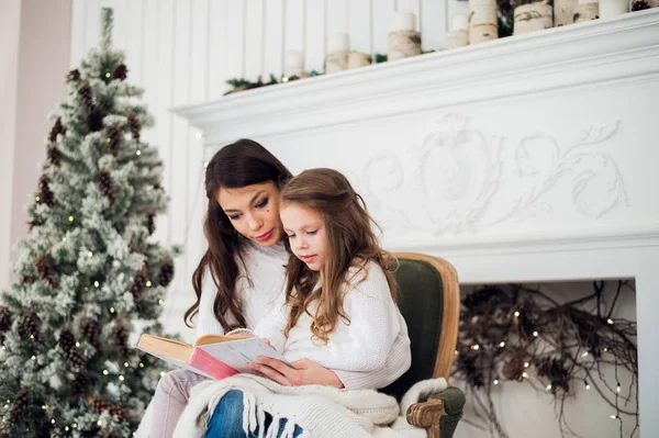 少女と彼女のお母さんはクリスマスに本を読んで — ストック写真