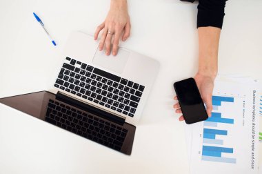 Laptop kadınlar el ve kağıt grafik üzerinde beyaz tablo ile.