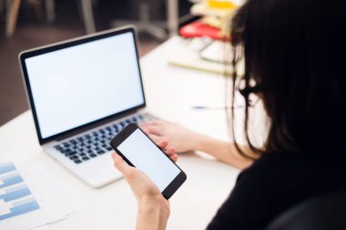 Cep telefonu ve laptop ofiste kullanarak kadının elleri