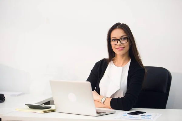 Joven mujer de negocios bonita con portátil portátil en la oficina — Foto de Stock