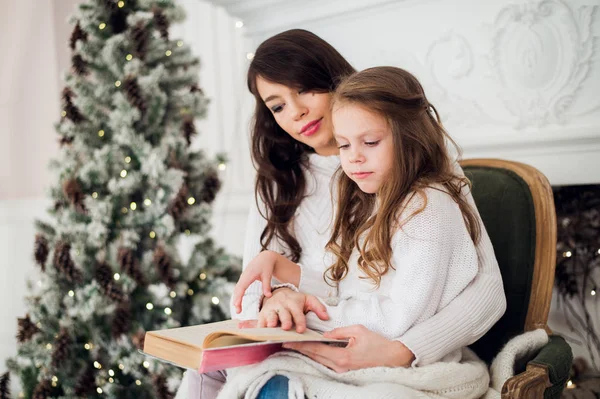 Chica y su mamá leyendo libro en Navidad — Foto de Stock