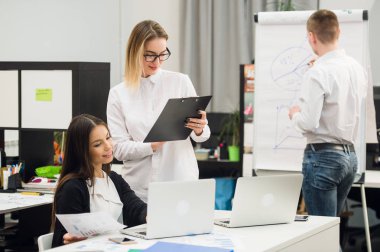 Güzel iş adamları kameraya bakıyor ve Office dururken gülümseyen