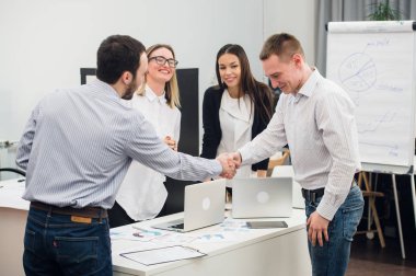 Gemiye hoş geldiniz. İki tanesi ise masada oturan dört iş adamları el sıkışan ve gülümseyen