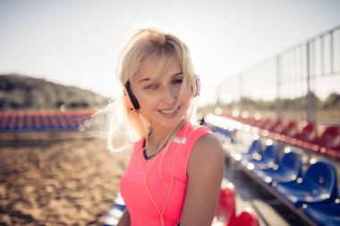 Plaj voleybol kadın oyuncu portre kulaklık ile gülümseyen.