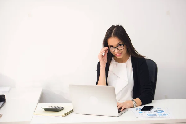 Joven mujer de negocios bonita con portátil portátil en la oficina —  Fotos de Stock