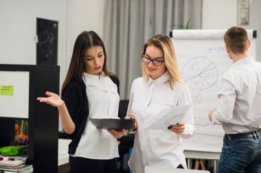 Konuşmayı adam meslektaşım iş stratejisi üzerinde flip grafik çizim sırasında iki güzel Ofis çalışanları.